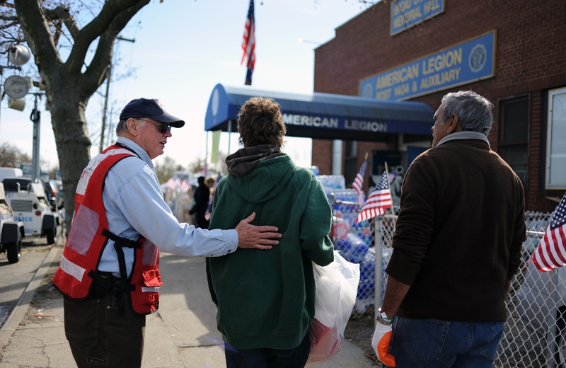 A Legionnaire provides assistance to members of his community.